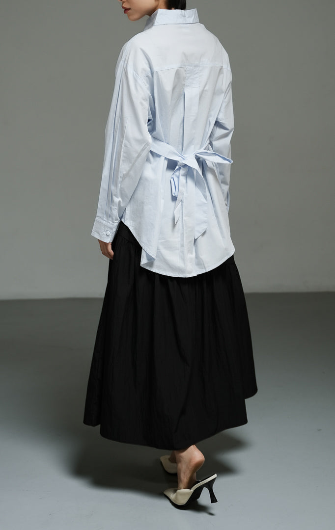 Atasan wanita model kemeja katun lengan panjang warna biru muda (light blue corseted waist shirt top) Effie Top dengan potongan korset yang memberikan siluet modern dan rapi. 