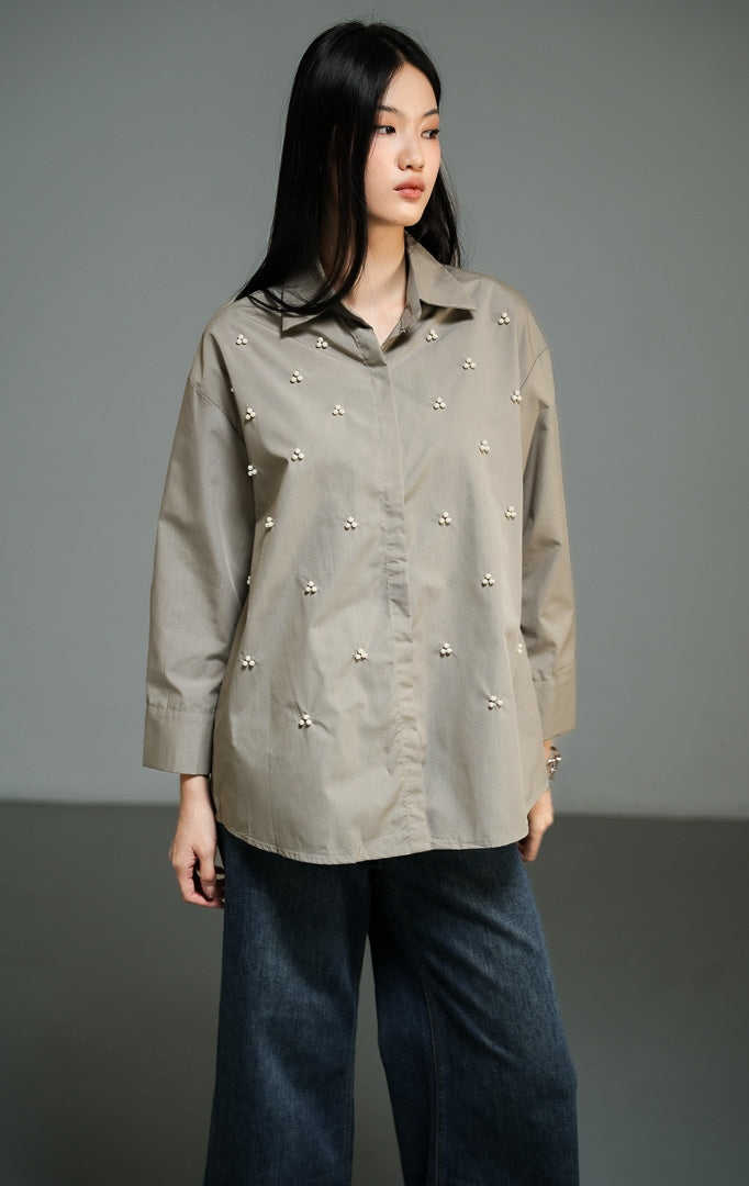 Kemeja wanita lengan panjang warna hijau olive (olive beaded button-down shirt) Freesia Top dengan detail hiasan manik-manik mutiara bentuk klaster bunga di bagian depan, kerah klasik, serta kancing penuh. 