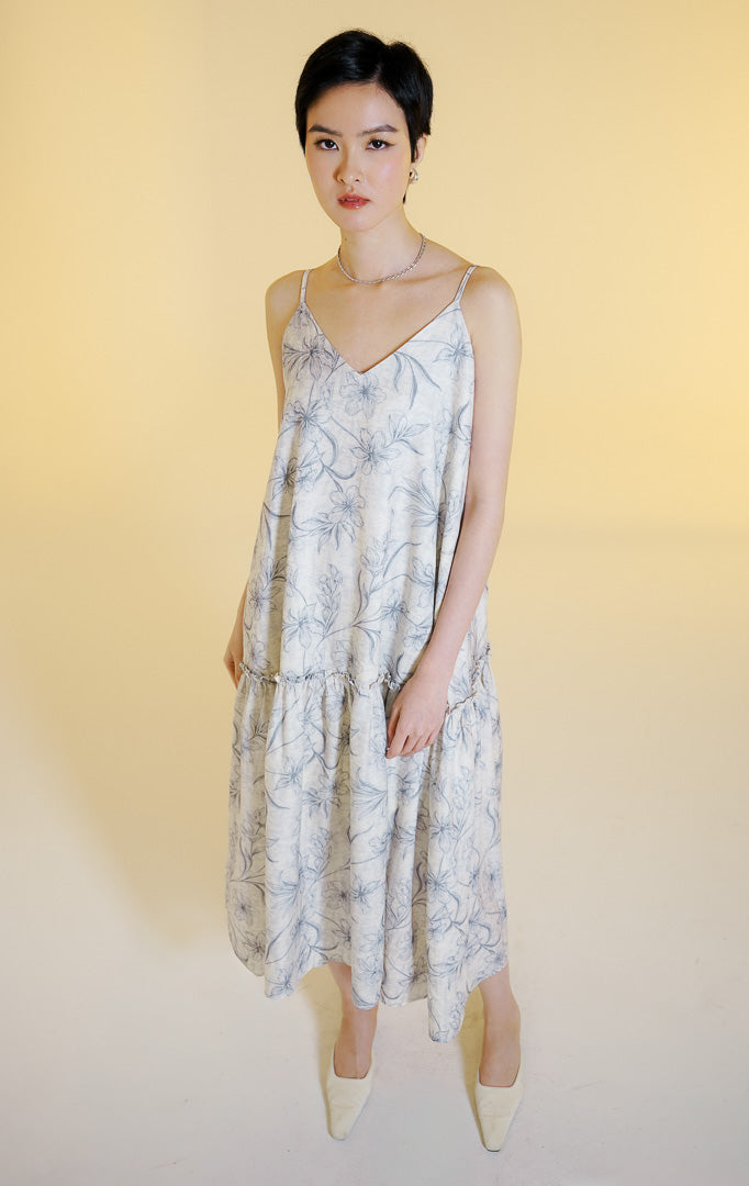 Pakaian wanita model gaun midi tali spageti motif bunga dengan detail kerutan ruffle seam (ruffle seam floral midi dress) warna abu-abu muda Fresla Dress untuk gaya kasual dan liburan. 