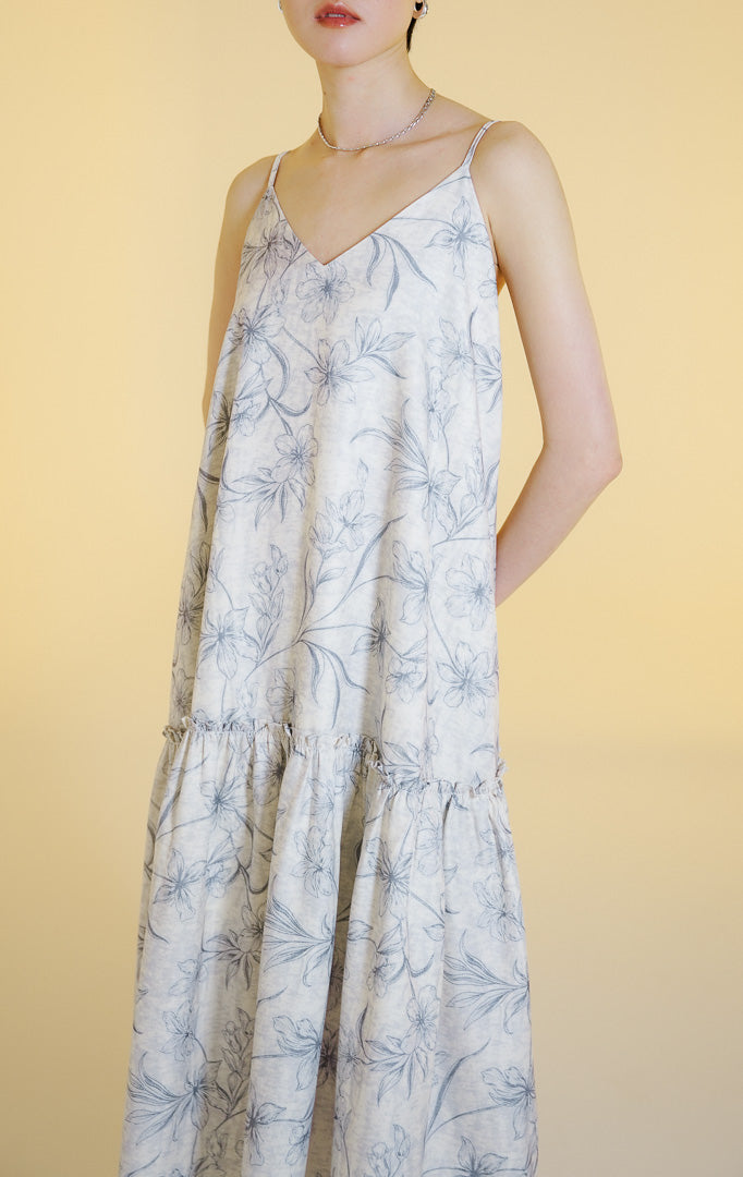 Pakaian wanita model gaun midi tali spageti motif bunga dengan detail kerutan ruffle seam (ruffle seam floral midi dress) warna abu-abu muda Fresla Dress untuk gaya kasual dan liburan. 