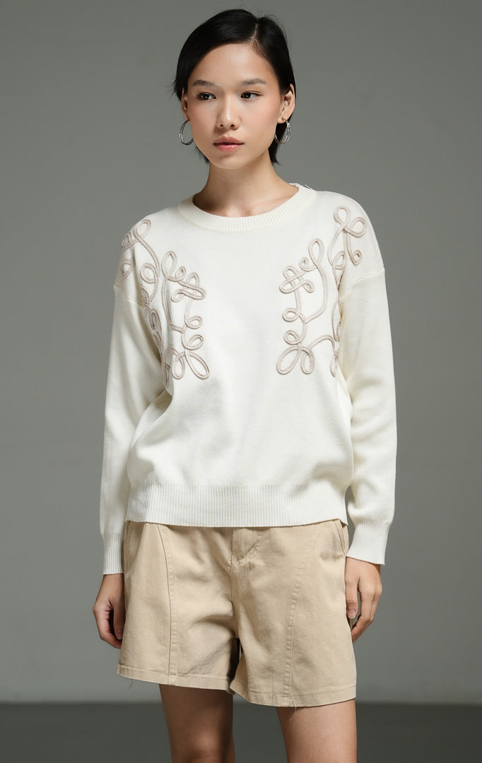 Atasan wanita model sweater rajut warna ivory dengan detail bordir tali bermotif bunga (ivory floral cord embroidery knit sweater) Jenny Sweater untuk tampilan kasual yang anggun. 
