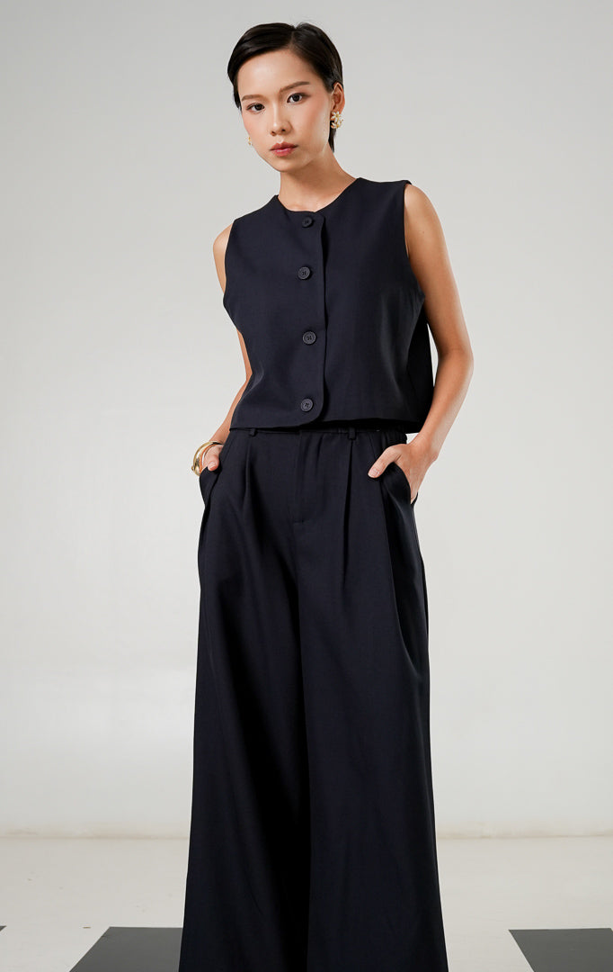 Rompi tanpa lengan (vest) wanita model klasik warna navy (biru dongker) dengan detail kancing depan dan kerah bulat dari This Is April. 