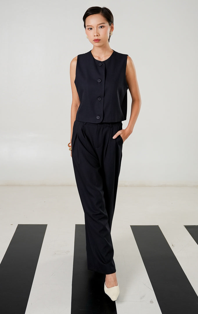 Rompi tanpa lengan (vest) wanita model klasik warna navy (biru dongker) dengan detail kancing depan dan kerah bulat dari This Is April. 