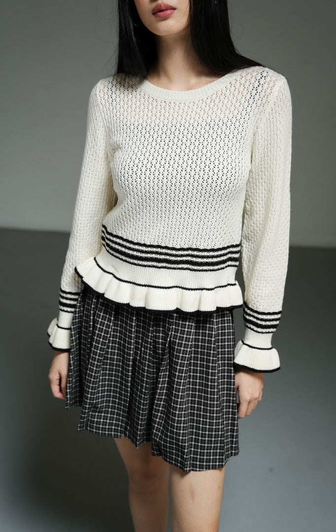 Cardigan rajut wanita lengan panjang warna putih gading (ivory ruffle-hem knit cardigan) Laurent Cardigan dengan detail ruffle halus di bagian lengan dan hem, aksen garis hitam, serta bahan rajut elastis yang nyaman untuk pelapis (layering).