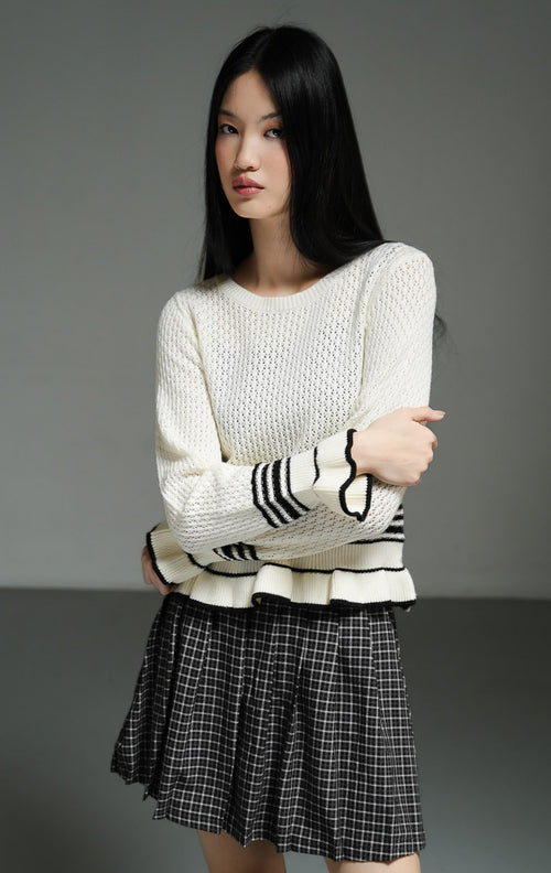 Cardigan rajut wanita lengan panjang warna putih gading (ivory ruffle-hem knit cardigan) Laurent Cardigan dengan detail ruffle halus di bagian lengan dan hem, aksen garis hitam, serta bahan rajut elastis yang nyaman untuk pelapis (layering). 