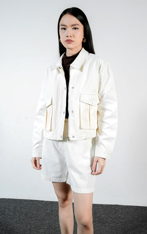 Pakaian wanita model jaket lengan panjang bahan katun warna ivory dengan detail saku penutup dan lipatan lipit (ivory box-pleated flap pocket jacket) Lisande Jacket untuk gaya kasual yang rapi. 