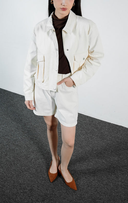 Pakaian wanita model jaket lengan panjang bahan katun warna ivory dengan detail saku penutup dan lipatan lipit (ivory box-pleated flap pocket jacket) Lisande Jacket untuk gaya kasual yang rapi. 