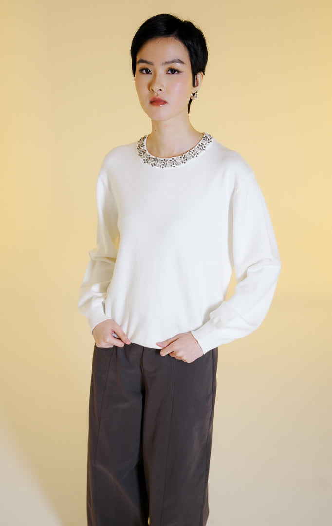 Pakaian hangat wanita model sweter rajut lengan panjang dengan hiasan manik-manik di bagian kerah bulat (beaded neckline knit sweater) warna putih Luella Sweater untuk gaya kasual elegan.