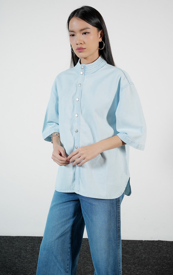 Pakaian wanita model kemeja denim lengan pendek warna biru muda dengan detail kerah quilting (quilted collar blouse) Maevelin Top untuk gaya kasual modern yang stylish. 