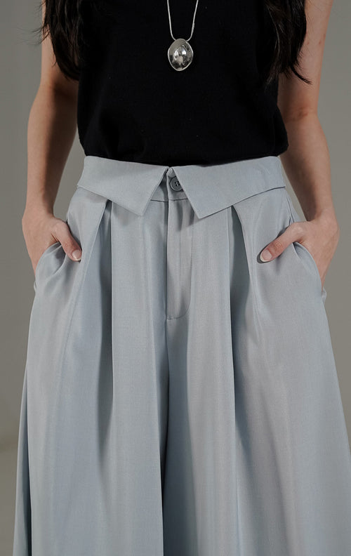 Celana kulot wanita Maia Pants Light Blue dari This Is April dengan detail pinggang lipat (lapel waist) dan karet elastis bagian belakang.