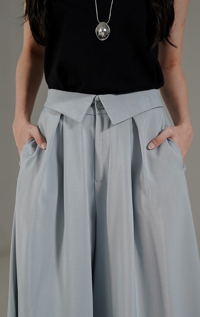 Celana kulot wanita Maia Pants Light Blue dari This Is April dengan detail pinggang lipat (lapel waist) dan karet elastis bagian belakang.