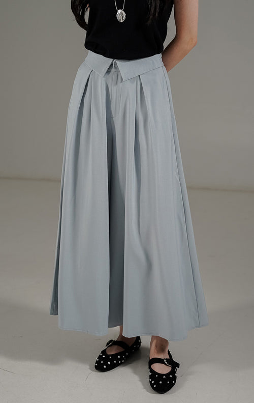 Celana kulot wanita Maia Pants Light Blue dari This Is April dengan detail pinggang lipat (lapel waist) dan karet elastis bagian belakang.