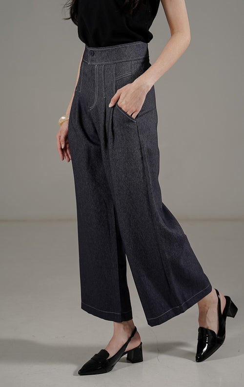 Marcela Pants Navy dari This Is April, celana panjang highwaist warna biru dongker dengan detail dua kancing depan dan saku samping.