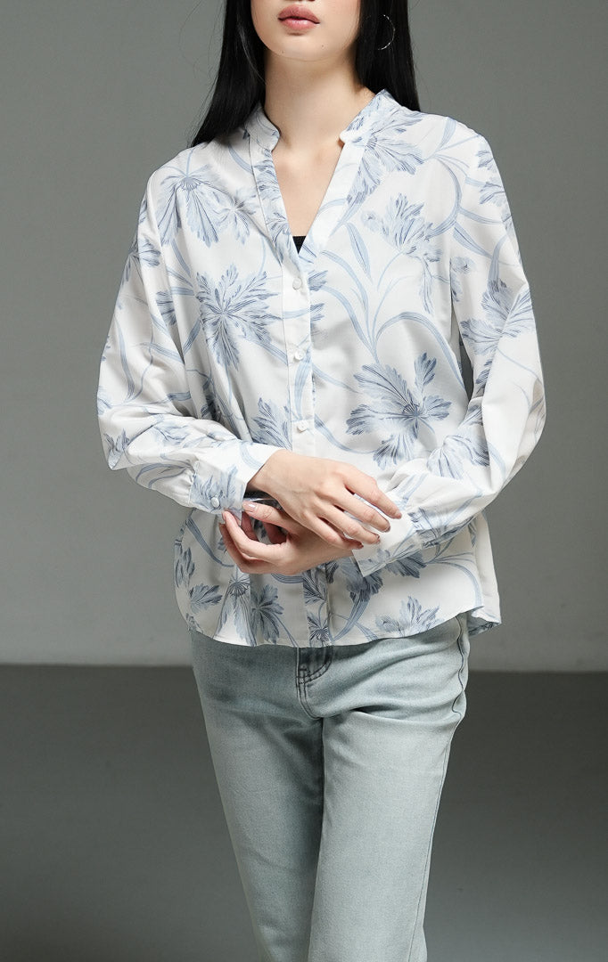 Kemeja wanita lengan panjang motif bunga warna biru muda (light blue floral print split collar top) Morven Top dengan detail kerah V belah, bahan poliester ringan bertekstur jatuh, serta kancing depan klasik. 