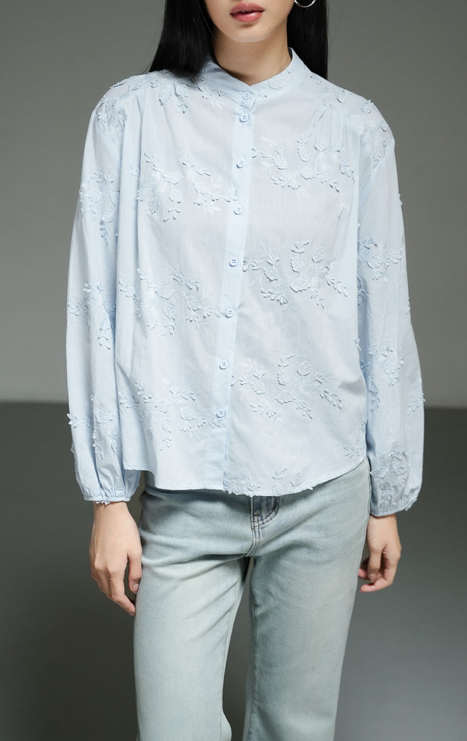 Blus wanita lengan panjang warna biru muda (light blue leaf embroidered cotton blouse) Nerine Top dengan detail sulam motif daun yang cantik, bahan katun non-stretch berstruktur, serta kancing depan yang rapi. 