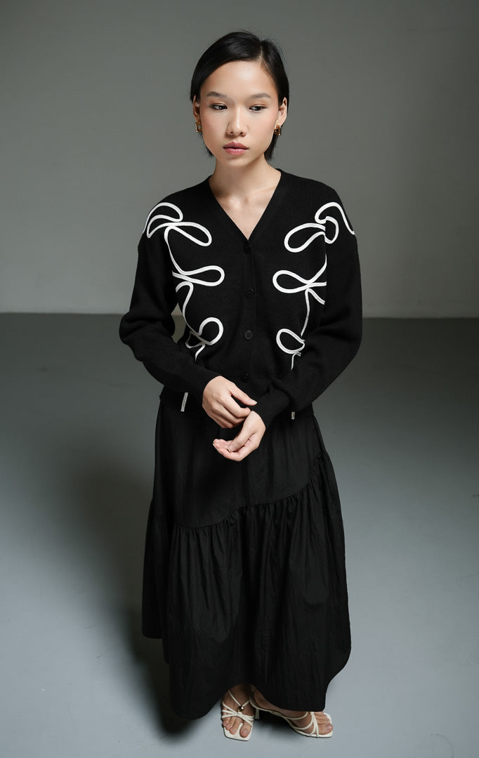 Atasan wanita model cardigan rajut warna hitam dengan detail bordir tali abstrak yang unik (black abstract cord embroidery cardigan) Nirexon Cardigan untuk gaya chic sehari-hari. 