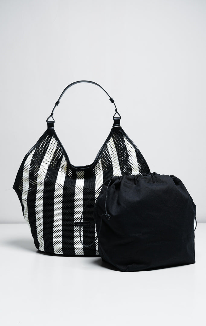 Tas wanita model hobo bag bahan rajut jaring motif garis warna hitam dan putih (black striped open-knit mesh hobo bag) Odessa Bag dengan detail tali pegangan yang nyaman dan elegan.
