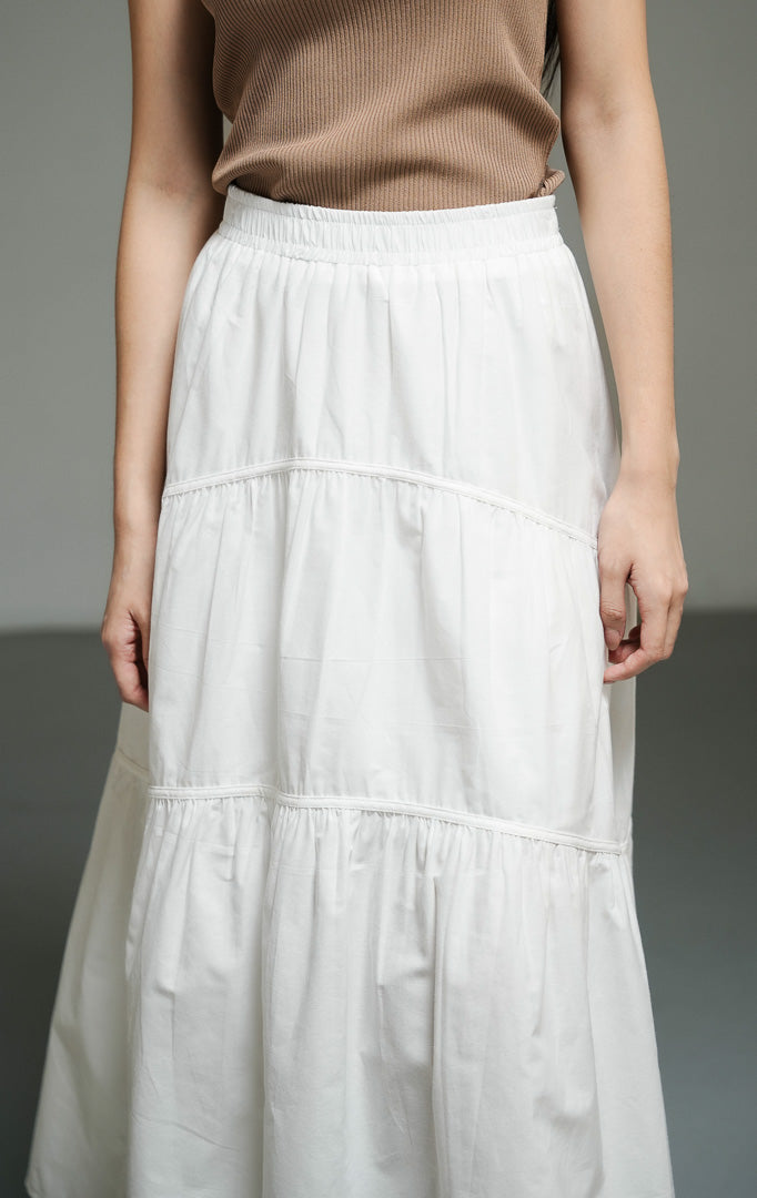 Rok panjang wanita model maxi flared warna putih (white gathered flared maxi skirt) Okeanos Skirt dengan konstruksi kerut yang anggun, potongan melebar yang jatuh sempurna, serta siluet kasual yang berkelas. 