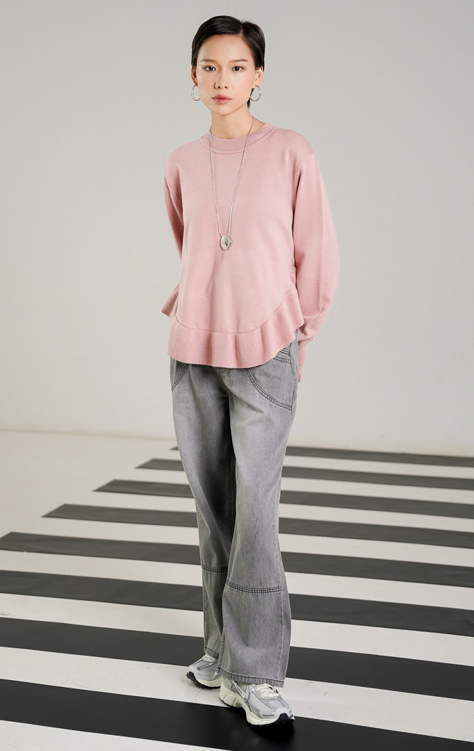 Sweater rajut wanita lengan panjang warna merah muda (pink) dengan detail hem ruffle bergelombang di bagian bawah dari This Is April. 