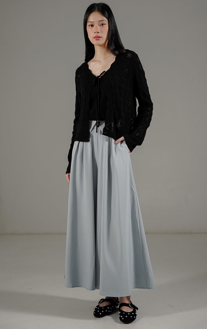  Robbie Cardigan Black dari This Is April, outer rajut berongga warna hitam dengan detail tali depan dan pinggiran bergelombang (scalloped edge).