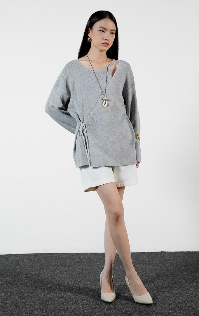 Pakaian wanita model sweater rajut lengan panjang model lilit silang asimetris dengan tali serut warna abu-abu muda (light grey asymmetrical wrap cross sweater) Salestia Sweater untuk gaya kasual yang trendi. 
