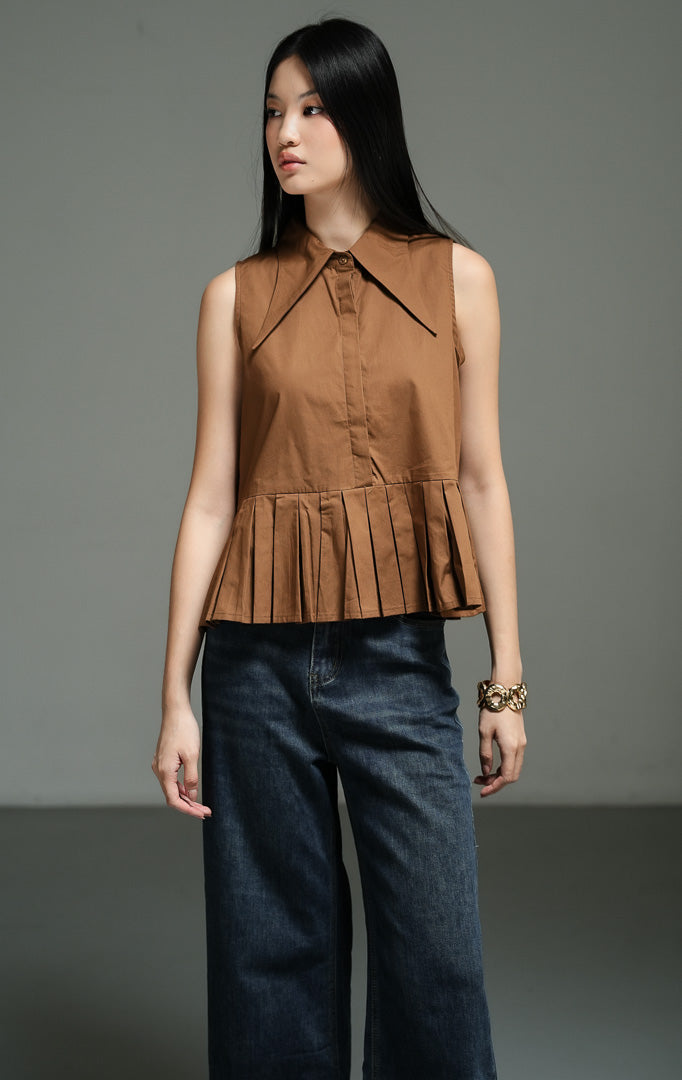 Atasan wanita tanpa lengan model peplum bervolume (exaggerated peplum top) warna cokelat (brown) Serelina Top dari bahan katun poplin terstruktur dengan potongan kerah lancip yang modern. 