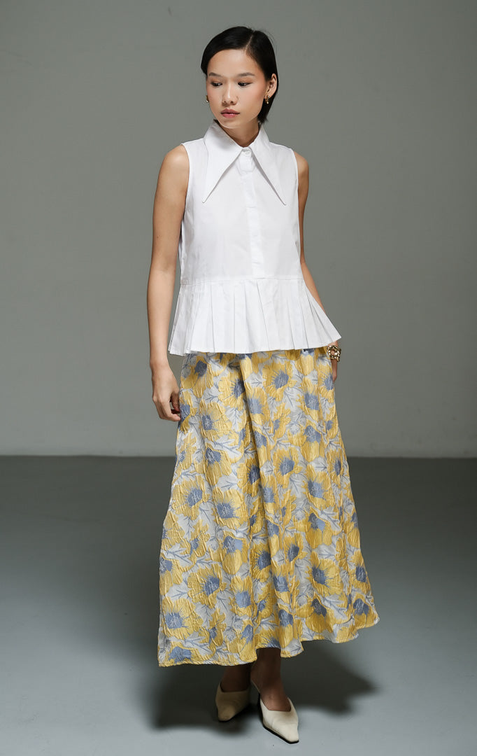 Atasan wanita tanpa lengan model peplum bervolume (exaggerated peplum top) warna putih (white) Serelina Top dari bahan katun poplin terstruktur dengan desain siluet struktural yang chic. 