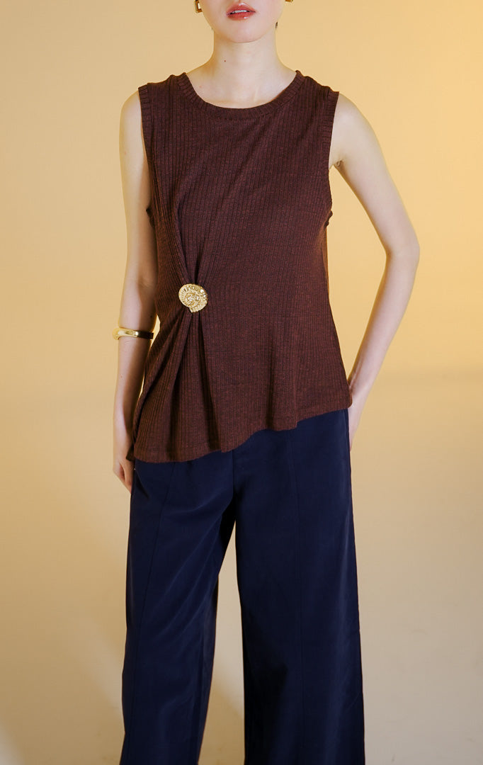 Pakaian wanita model atasan rajut tanpa lengan kerah bulat dengan aksen bros berbentuk kerang warna emas (gold shell brooch sleeveless knit top) warna cokelat tua Vareena Top untuk gaya kantor dan kasual anggun. 