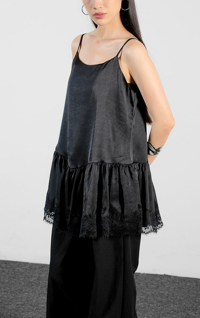 Pakaian wanita model atasan kamisol tali spageti bahan poliester dengan detail lapisan bertingkat dan aksen renda di bagian bawah (tiered flounce hem camisole top) warna hitam Velicia Top untuk gaya kasual feminin. 