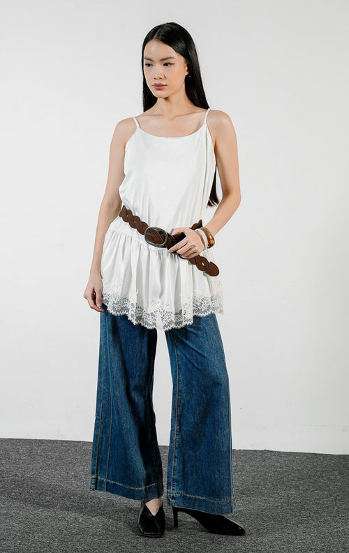 Pakaian wanita model atasan kamisol tali spageti bahan poliester dengan detail lapisan bertingkat dan aksen renda di bagian bawah (tiered flounce hem camisole top) warna putih Velicia Top untuk gaya kasual feminin. 