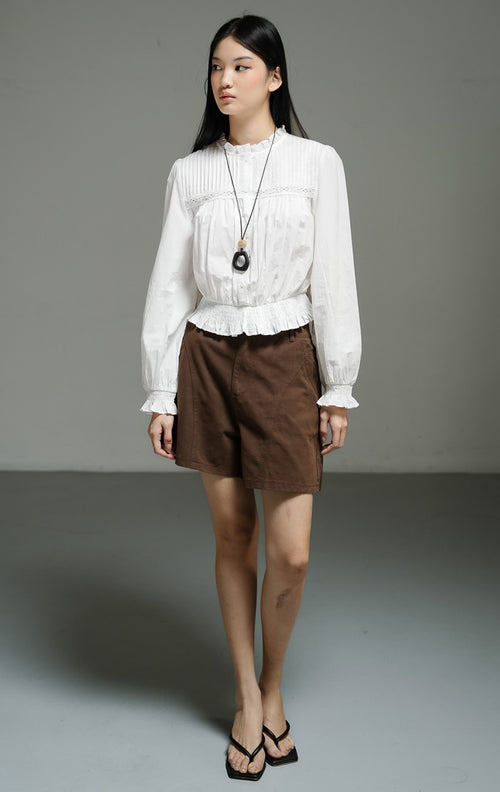 Atasan wanita model blus peplum lengan panjang warna putih (white pin-tucked peplum blouse) Violetta Top dengan detail lipatan pin-tuck yang bertekstur serta potongan pinggang yang anggun. 