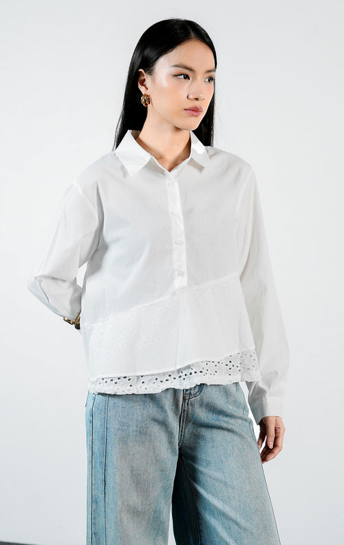Pakaian wanita model kemeja katun lengan panjang dengan detail bordir lubang pada bagian bawah peplum (eyelet broderie peplum shirt) warna putih Yoren Top untuk gaya kasual elegan yang chic. 