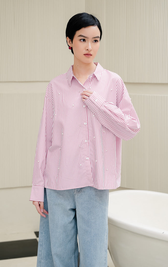 Kemeja lengan panjang wanita Tigris Top warna red (merah) motif stripe (salur) berpotongan relaxed fit dengan hiasan mutiara (pearl embellishments). 