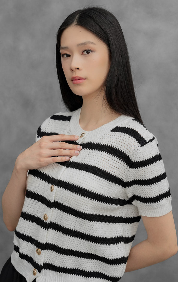 tinamarie perforated striped knit outer whiteLuaran rajut (outer) wanita lengan pendek warna putih (white) dengan motif garis-garis hitam Tinamarie Outer berbahan perforated knit, kerah bulat, dan kancing depan warna emas.