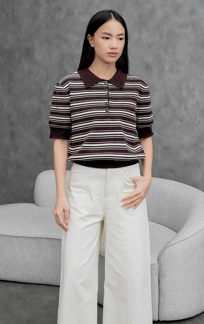 Atasan rajut wanita lengan pendek warna cokelat tua (dark brown) Varnel Top bermotif garis horizontal (striped) dengan kerah polo dan bukaan kancing depan. 