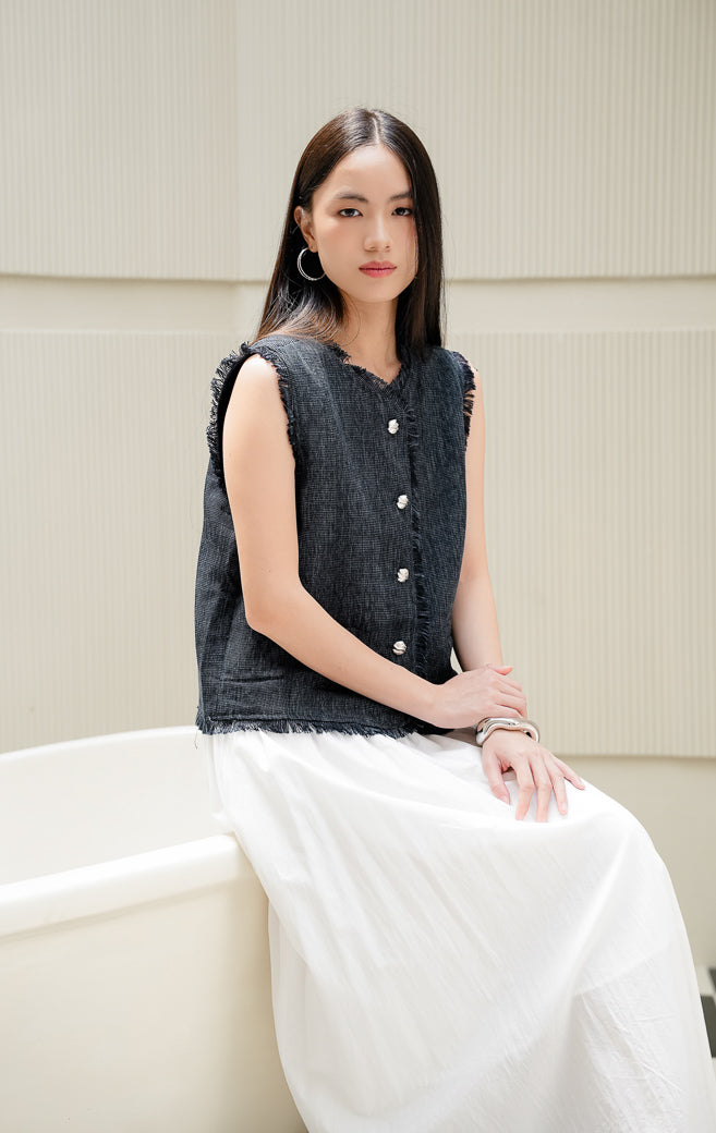 Rompi vest wanita tanpa lengan Vera Vest warna navy biru tua bahan tweed dengan detail aksen fringe serabut halus dan kancing depan. 