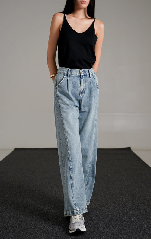 Vespera Pants Light Denim, celana jeans biru muda potongan lurus (straight leg) dengan detail lipatan depan, dipadukan dengan tank top hitam dan sneakers.