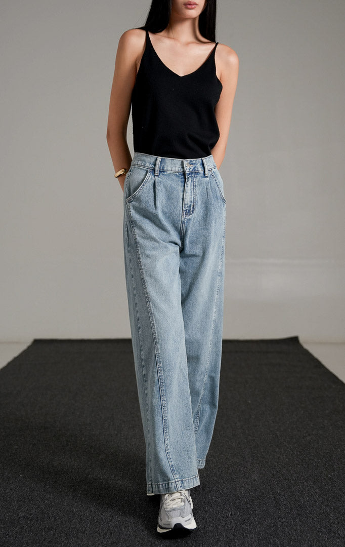 Vespera Pants Light Denim, celana jeans biru muda potongan lurus (straight leg) dengan detail lipatan depan, dipadukan dengan tank top hitam dan sneakers.
