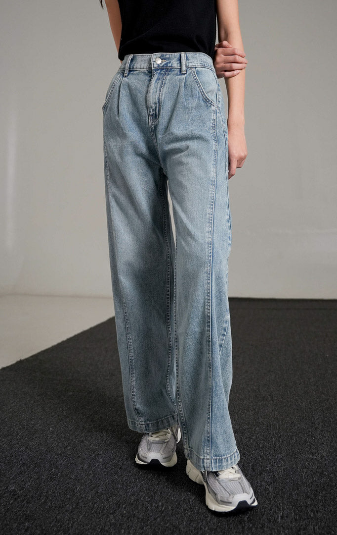Vespera Pants Light Denim, celana jeans biru muda potongan lurus (straight leg) dengan detail lipatan depan, dipadukan dengan tank top hitam dan sneakers.
