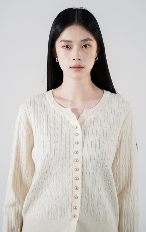 Vinnie Cardigan warna ivory, kardigan rajut kabel (cable knit) lengan panjang dengan detail kancing emas, dipadukan dengan rok plisket cokelat1