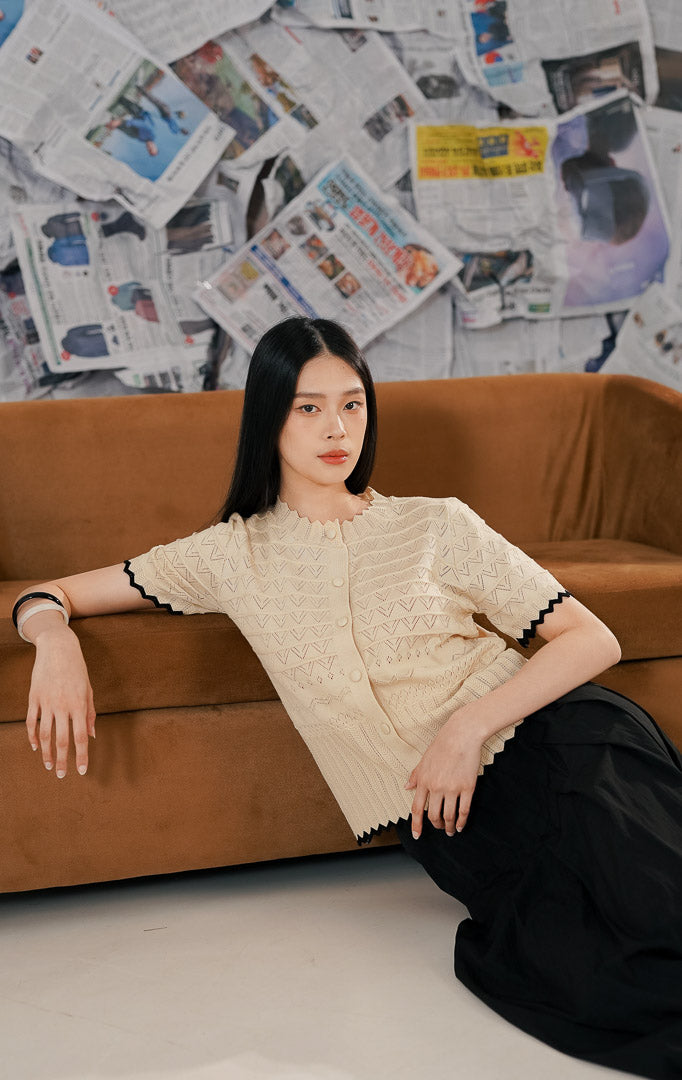 Model mengenakan Westly Top Ivory, atasan rajut wanita warna putih gading (cream) yang lembut, bahan melar (stretch) nyaman dengan kancing depan.