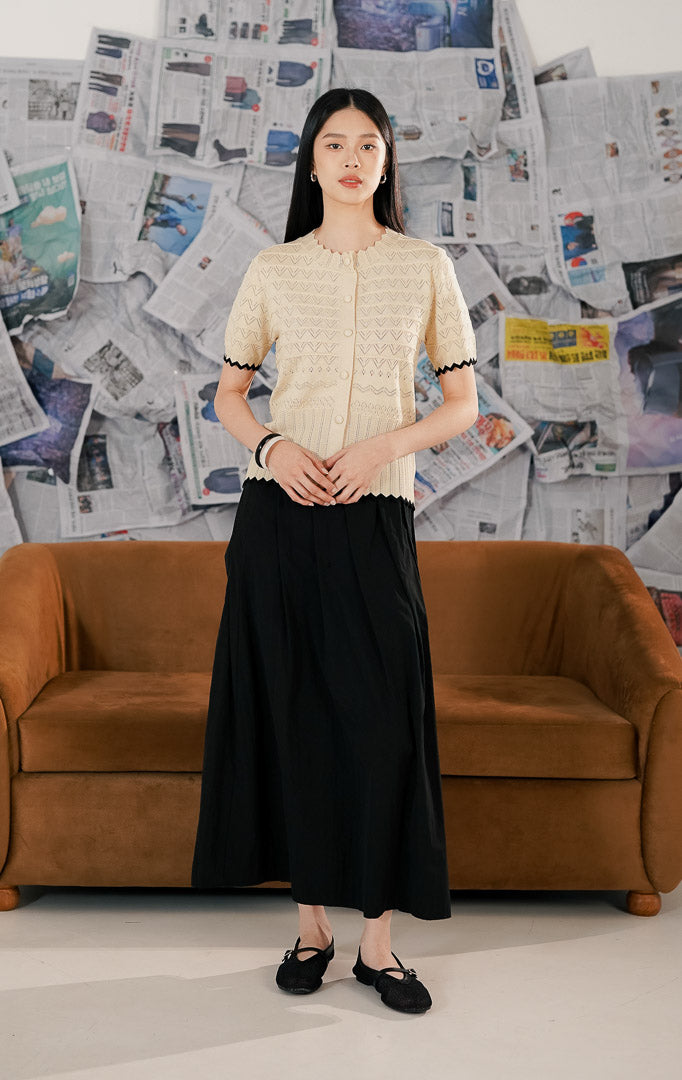 Model mengenakan Westly Top Ivory, atasan rajut wanita warna putih gading (cream) yang lembut, bahan melar (stretch) nyaman dengan kancing depan.