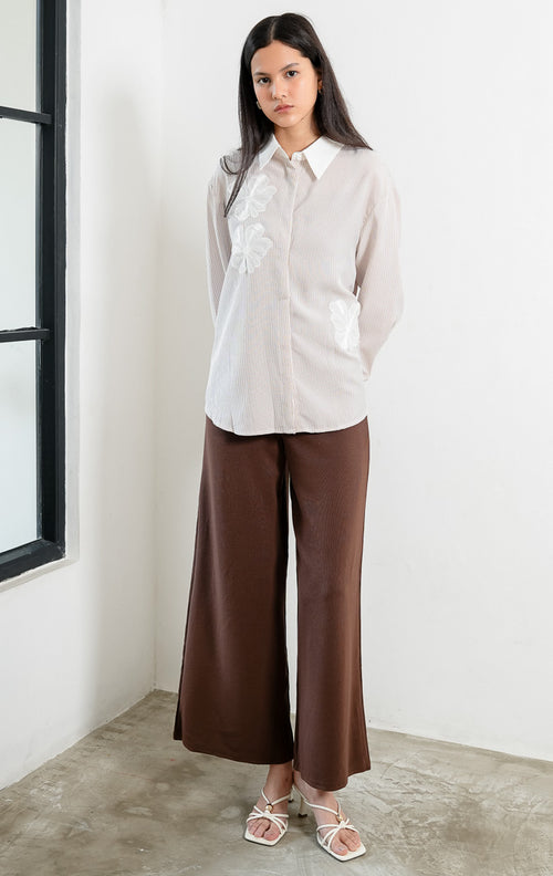 Kemeja wanita lengan panjang motif garis-garis cokelat (brown vertical stripes) Wilfred Top dengan detail aplikasi bordir bunga (embroidered floral motifs), kerah dan manset kontras putih (contrasting pointed collar and cuffs), serta bukaan kancing depan. 