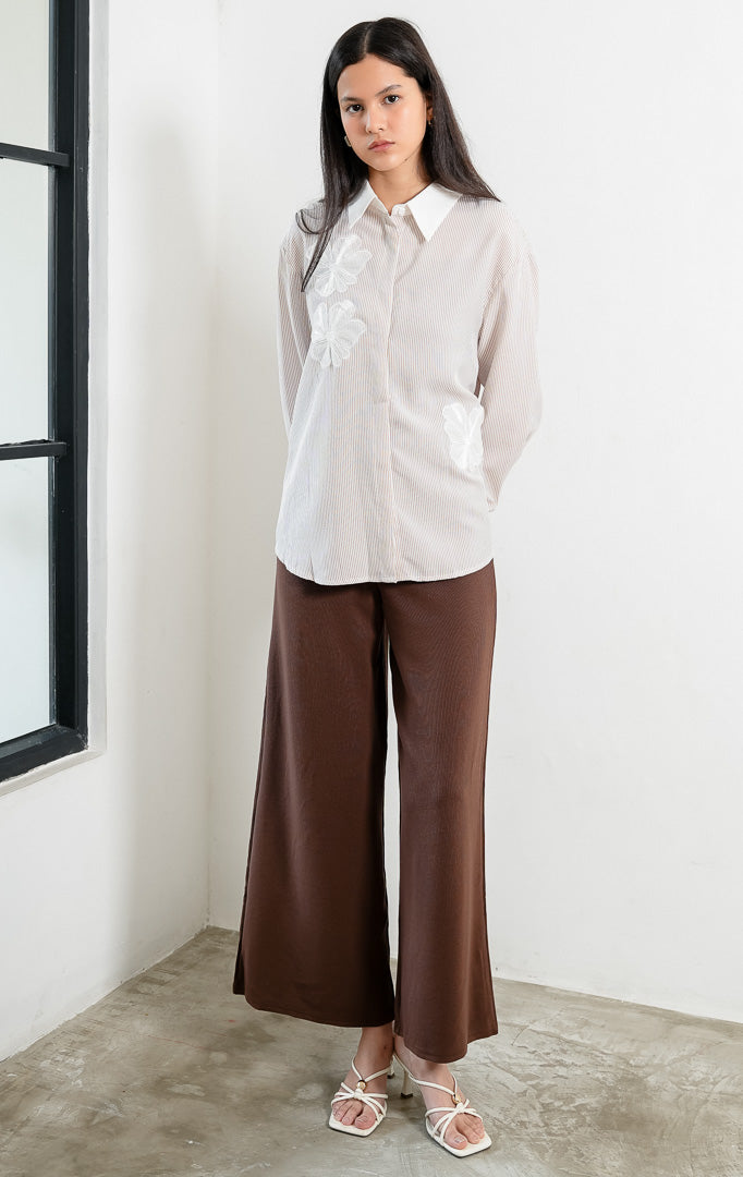 Kemeja wanita lengan panjang motif garis-garis cokelat (brown vertical stripes) Wilfred Top dengan detail aplikasi bordir bunga (embroidered floral motifs), kerah dan manset kontras putih (contrasting pointed collar and cuffs), serta bukaan kancing depan. 