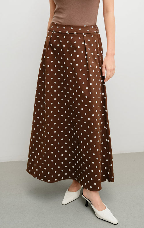 Rok panjang wanita model A-line (flare skirt) warna cokelat tua (dark brown) Willona Skirt berbahan katun motif polkadot dengan pinggang karet (elastic waistband).