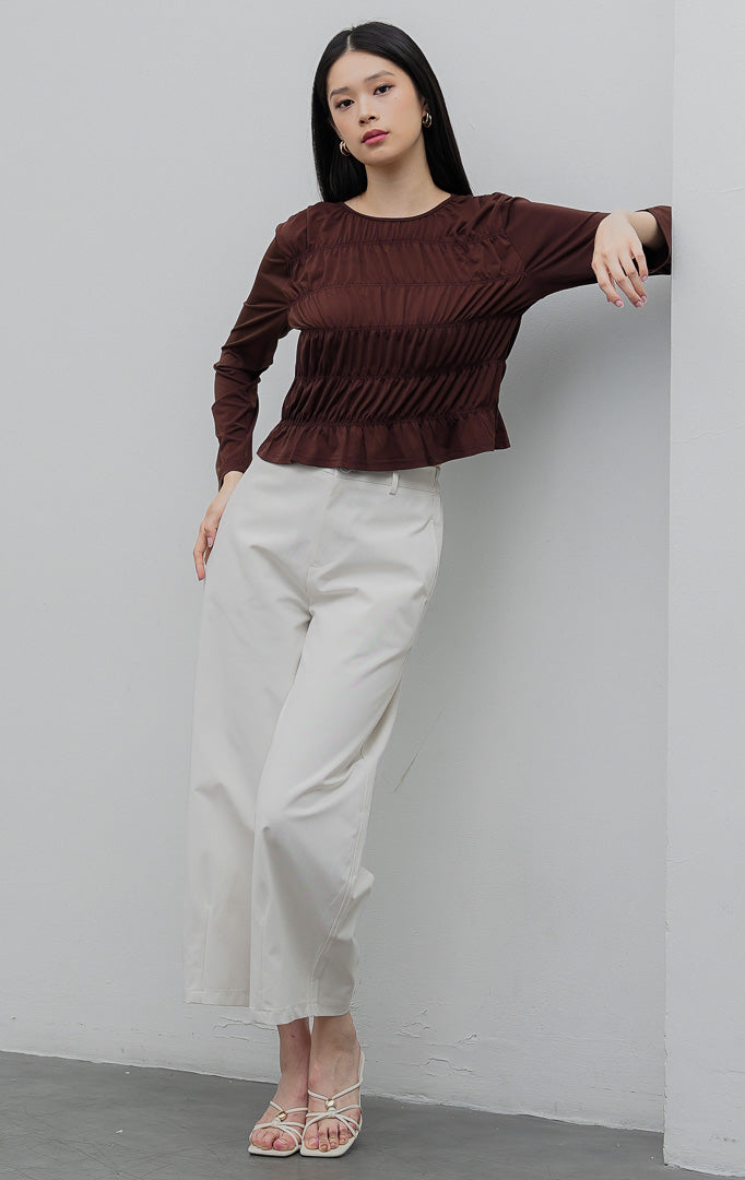 Atasan blus wanita lengan panjang warna cokelat tua (dark brown) Yuliana Top berbahan jersey stretch dengan aksen dada kerut (smocked bodice) dan kancing belakang. 