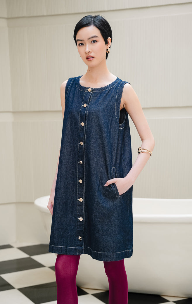 Dress denim wanita tanpa lengan warna biru Zephyr Dress dengan potongan straight-fit, kancing depan (button closure), dan detail saku double-welt.