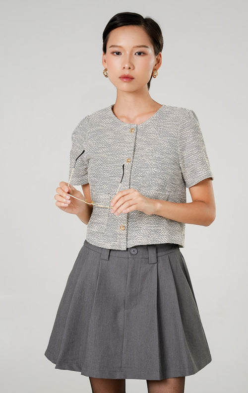 Atasan rajut wanita Zoya Top Grey dengan tekstur motif tweed, lengan pendek, kancing emas vertikal, dan saku dekoratif depan dari This Is April.