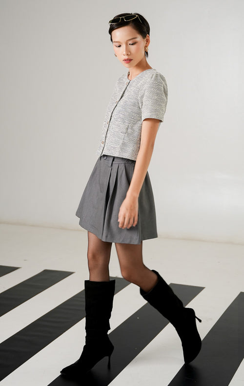Atasan rajut wanita Zoya Top Grey dengan tekstur motif tweed, lengan pendek, kancing emas vertikal, dan saku dekoratif depan dari This Is April.